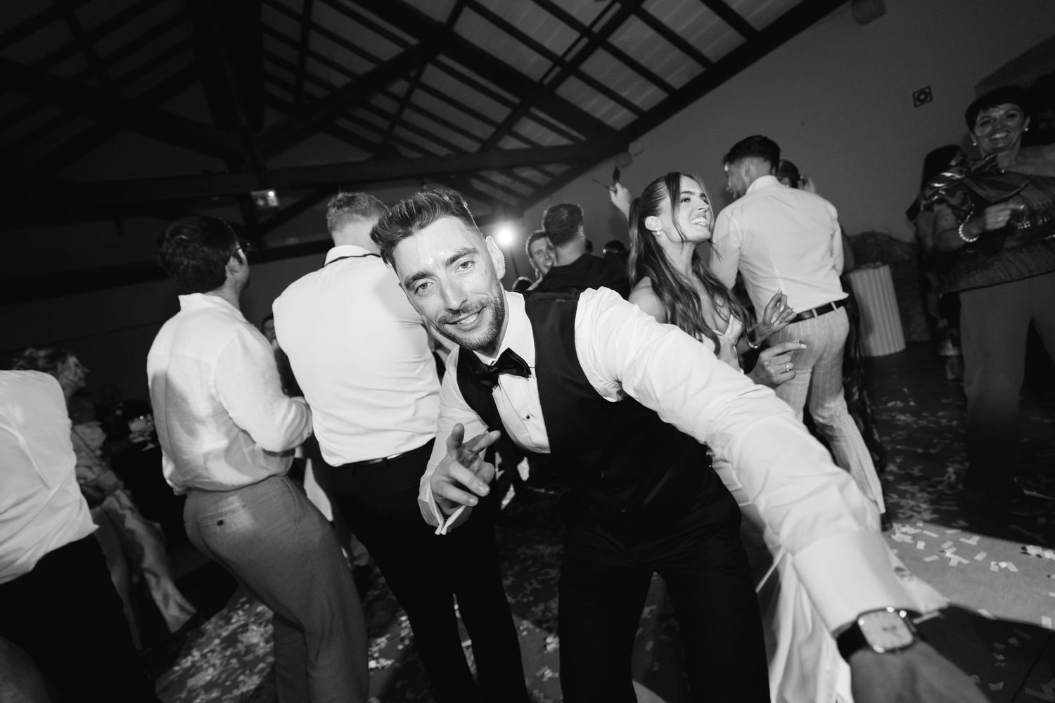 A candid moment of dancing and celebration at a wedding reception.
