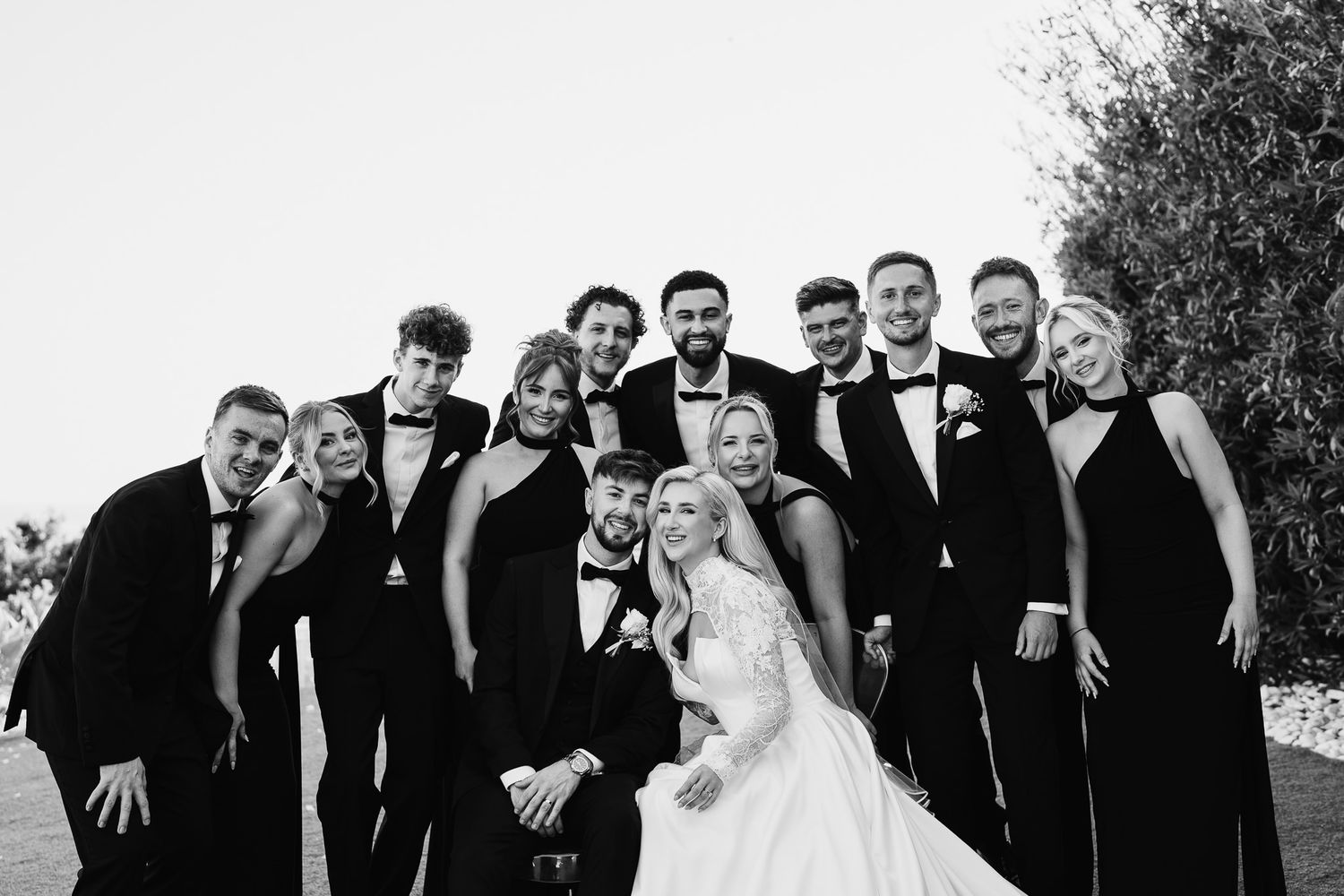 Candid moment of wedding party laughing together during outdoor photo session.