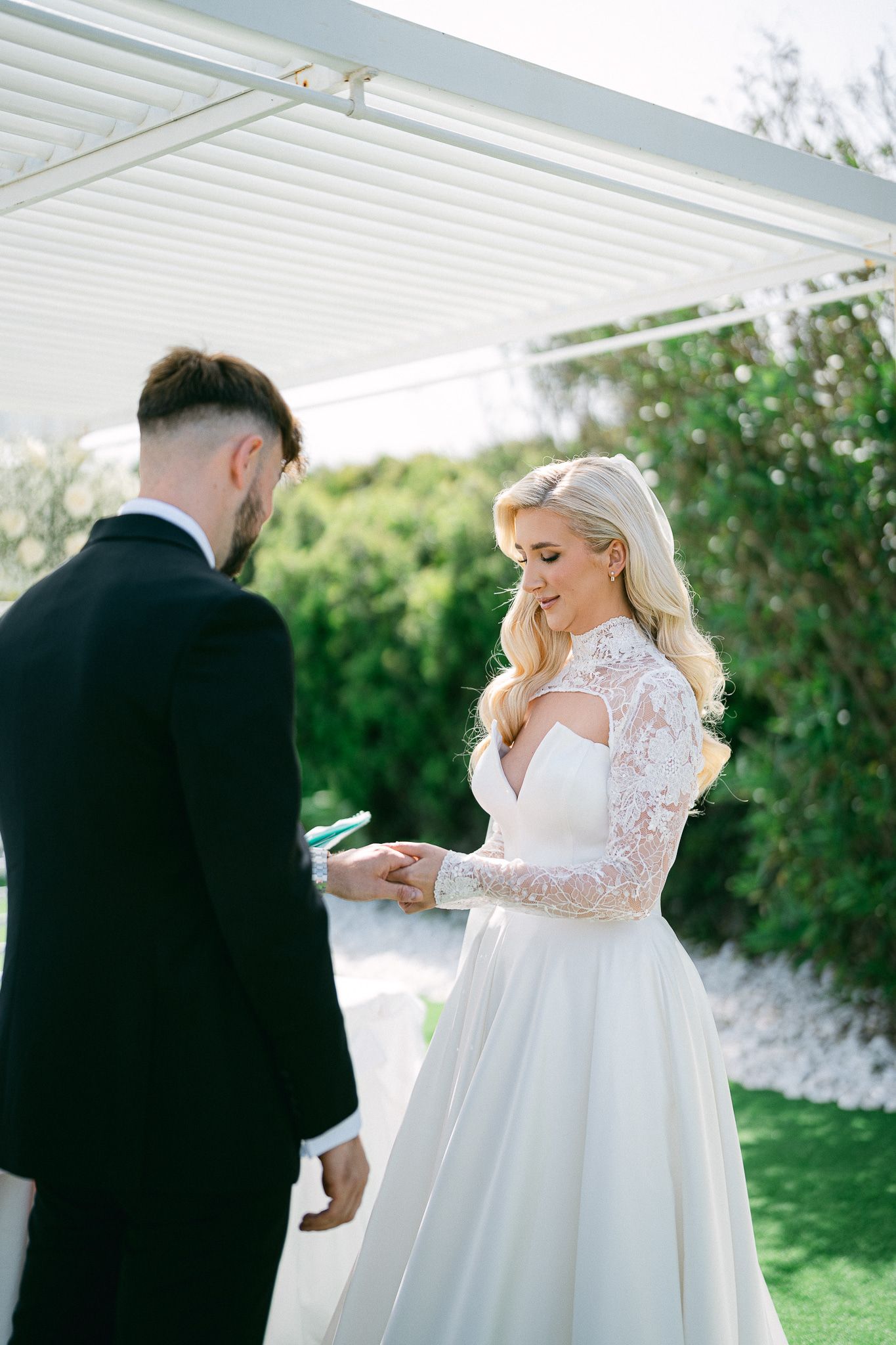 Emotional first look sequence between bride and groom at an outdoor wedding venue.