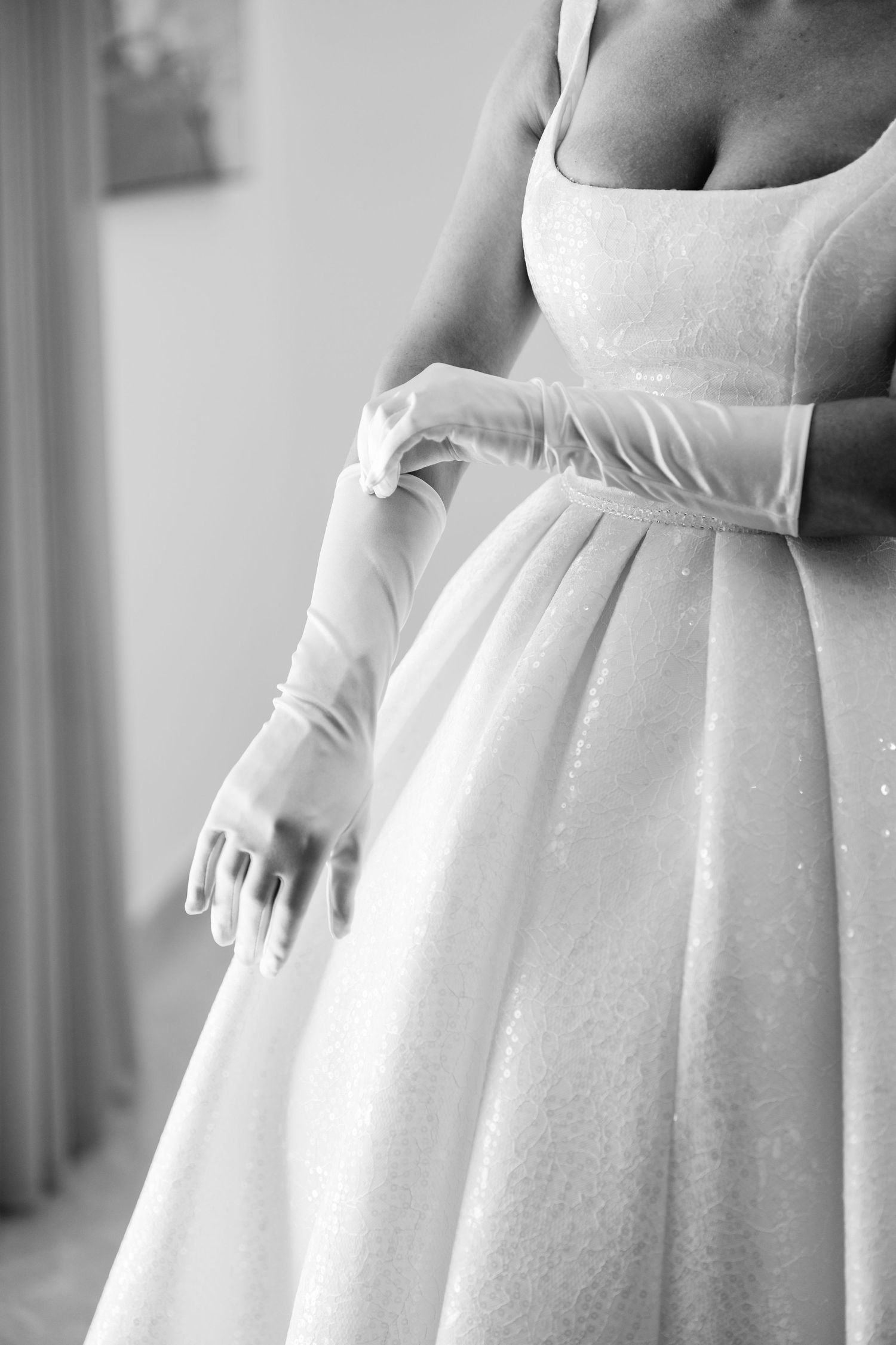 Detail shots of white wedding dress bodice and pleated skirt.