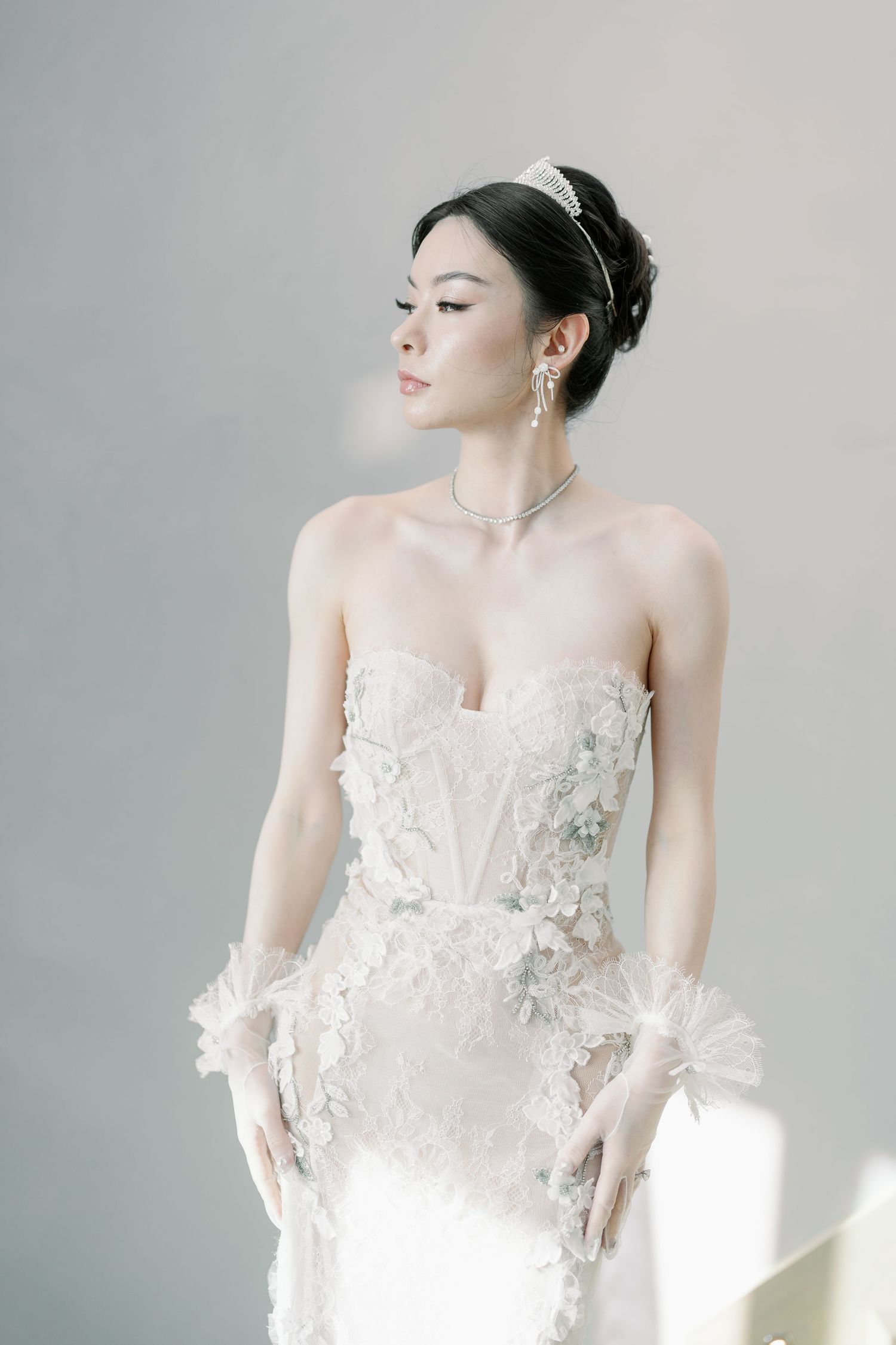 Artistic bridal portrait featuring a romantic white wedding gown with floral appliques.