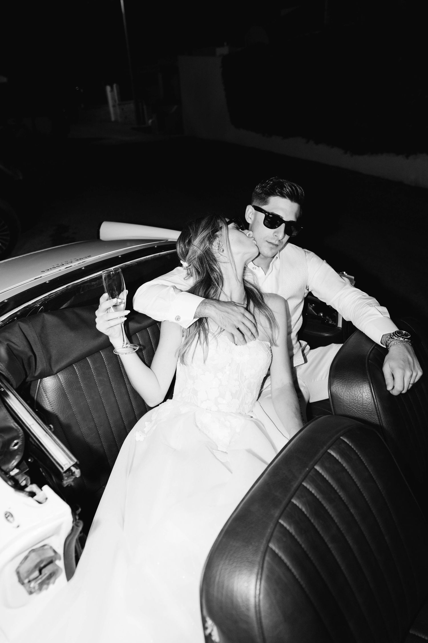 bride and groom sitting in classic car