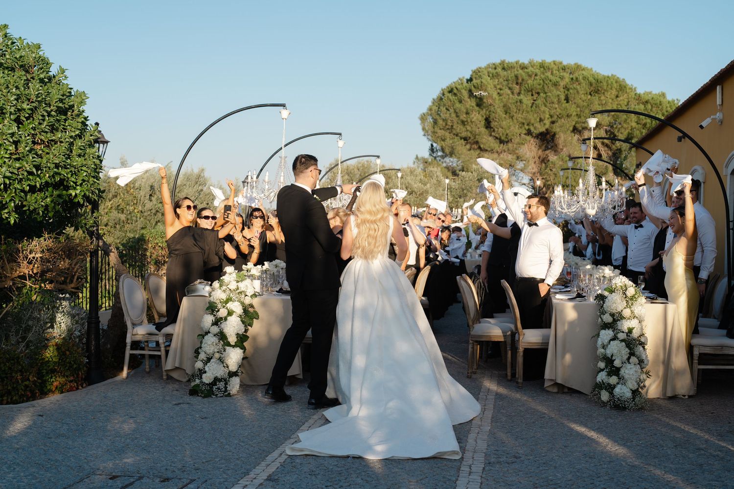 Wedding celebration on an outdoor terrace with guests gathered around the newlyweds.