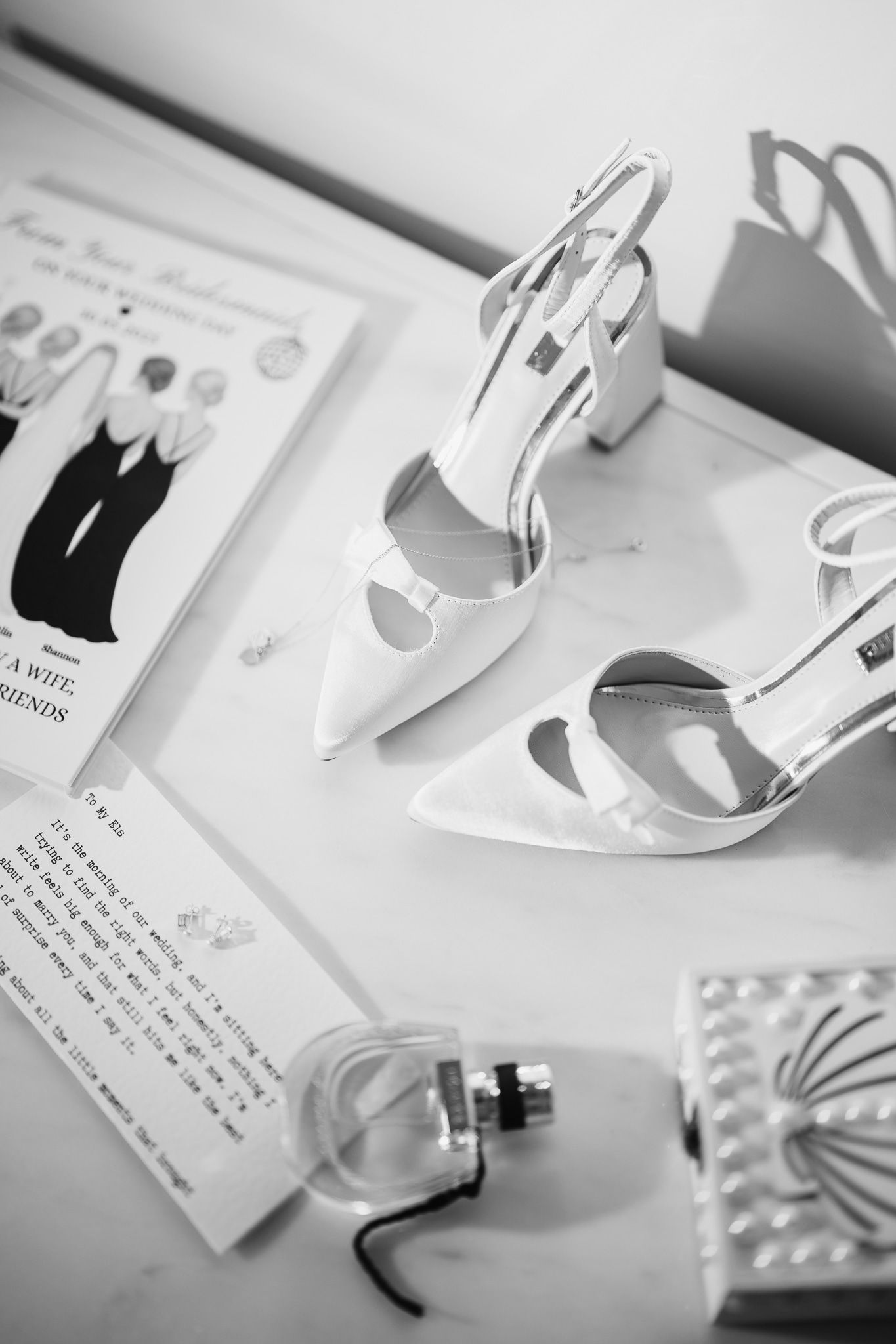 Wedding day details and accessories arranged artistically in black and white.