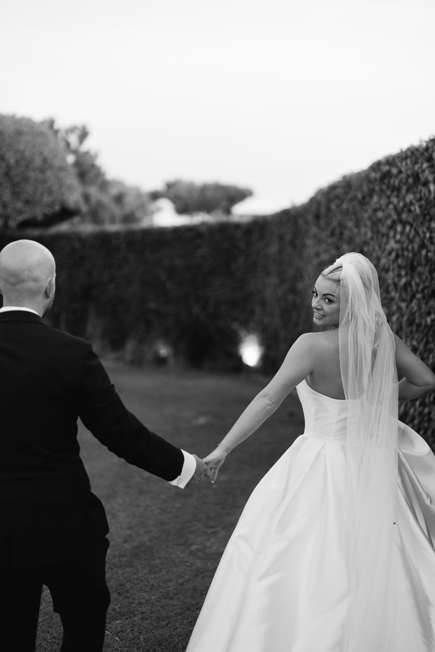 Romantic black and white wedding portrait sequence in garden setting.