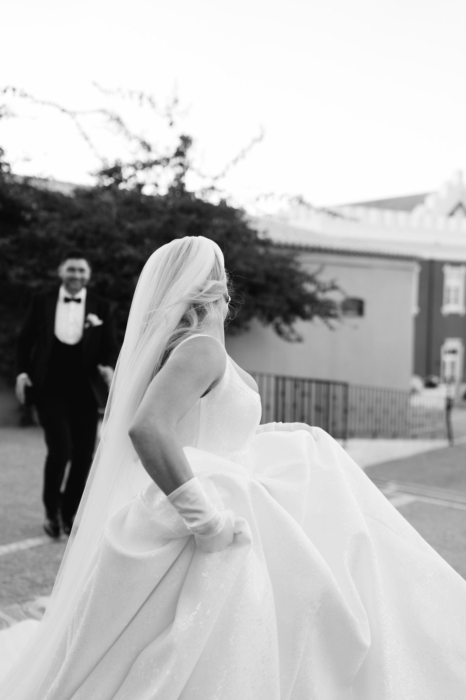 Flowing white wedding dress billowing in the breeze during an outdoor photoshoot.