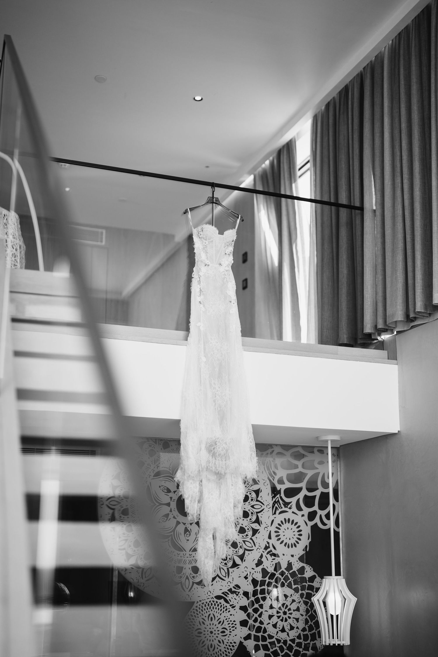 Wedding gown suspended in modern interior with geometric wall decorations.