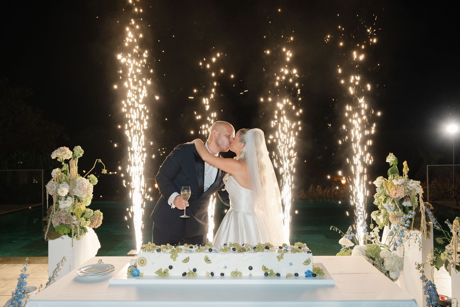 Sparklers create a magical backdrop as newlyweds celebrate at their evening reception.