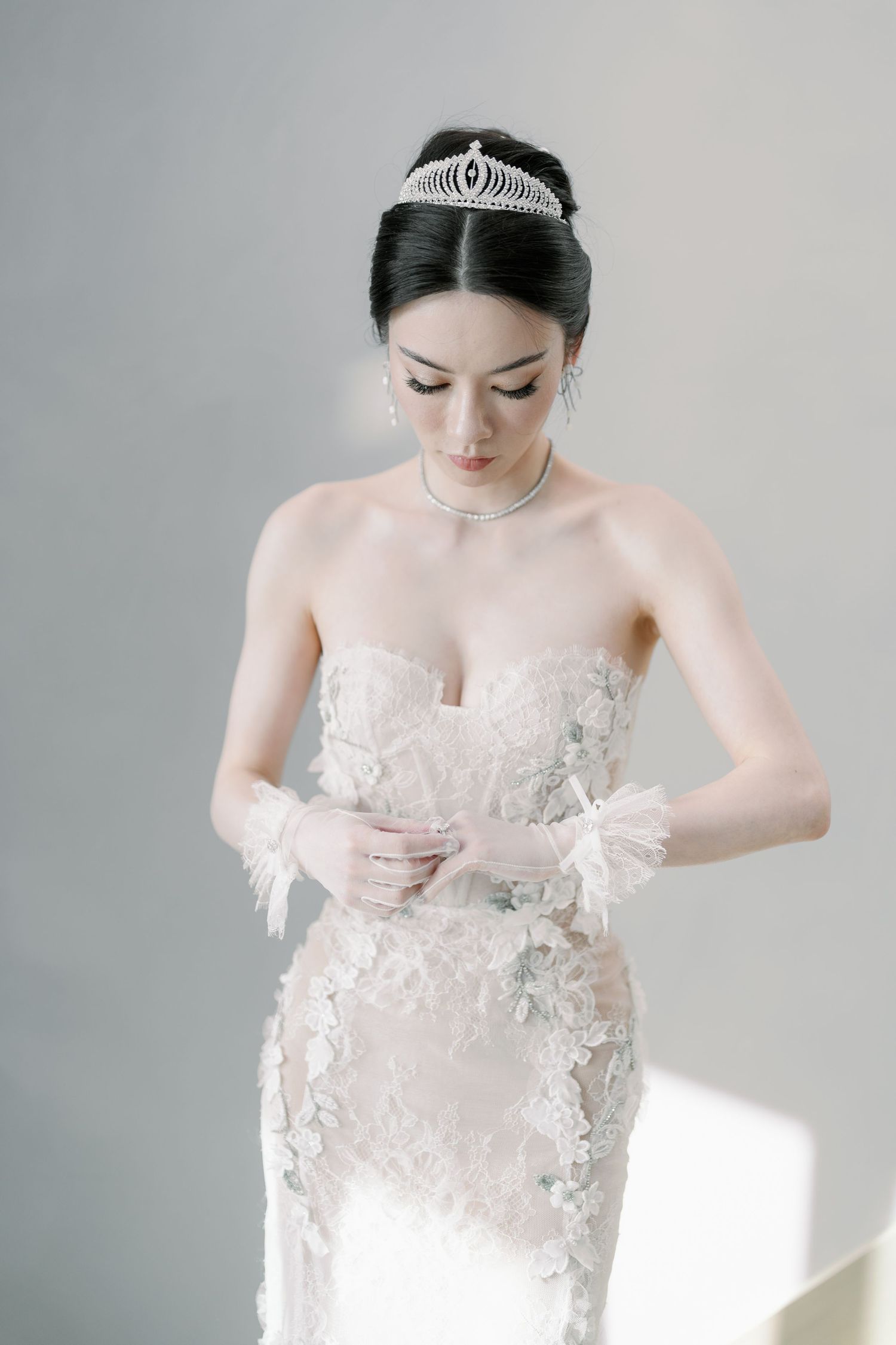 Soft, ethereal bridal portrait highlighting intricate wedding dress details in natural light.