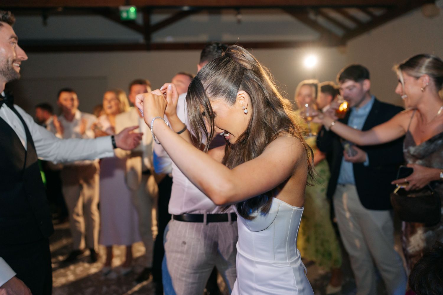 A bride dancing energetically during her wedding reception celebration.