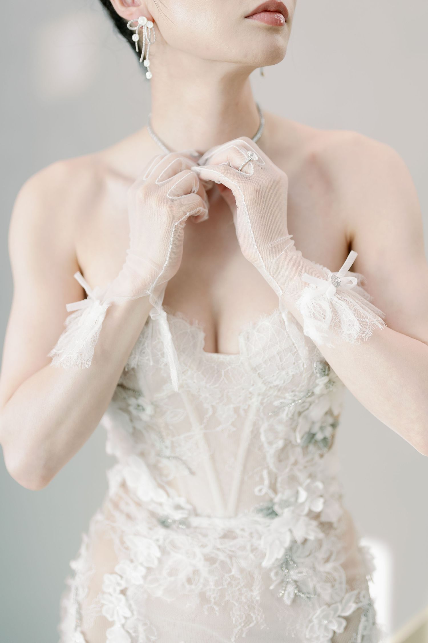 Delicate white wedding gown with intricate lace details and sheer elements.
