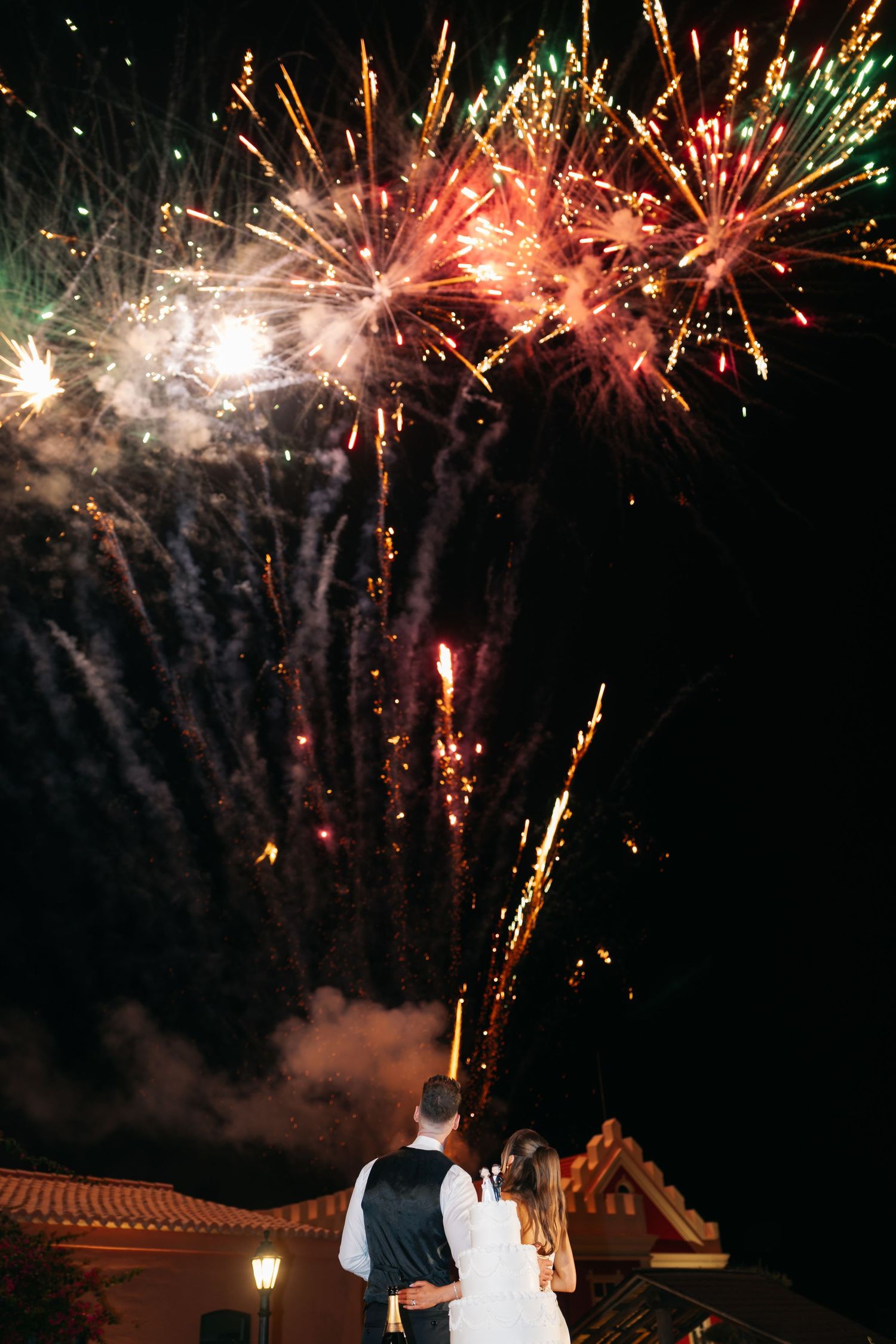 Red and white fireworks create a romantic backdrop for a wedding celebration.