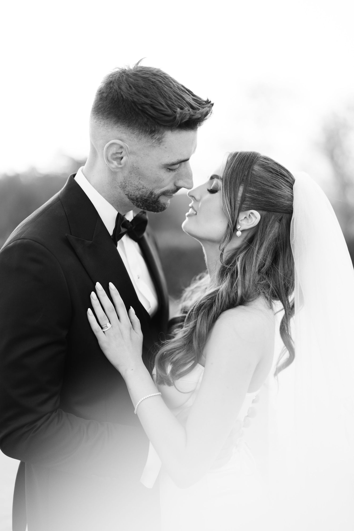 An intimate black and white portrait of a wedding couple sharing a romantic moment.
