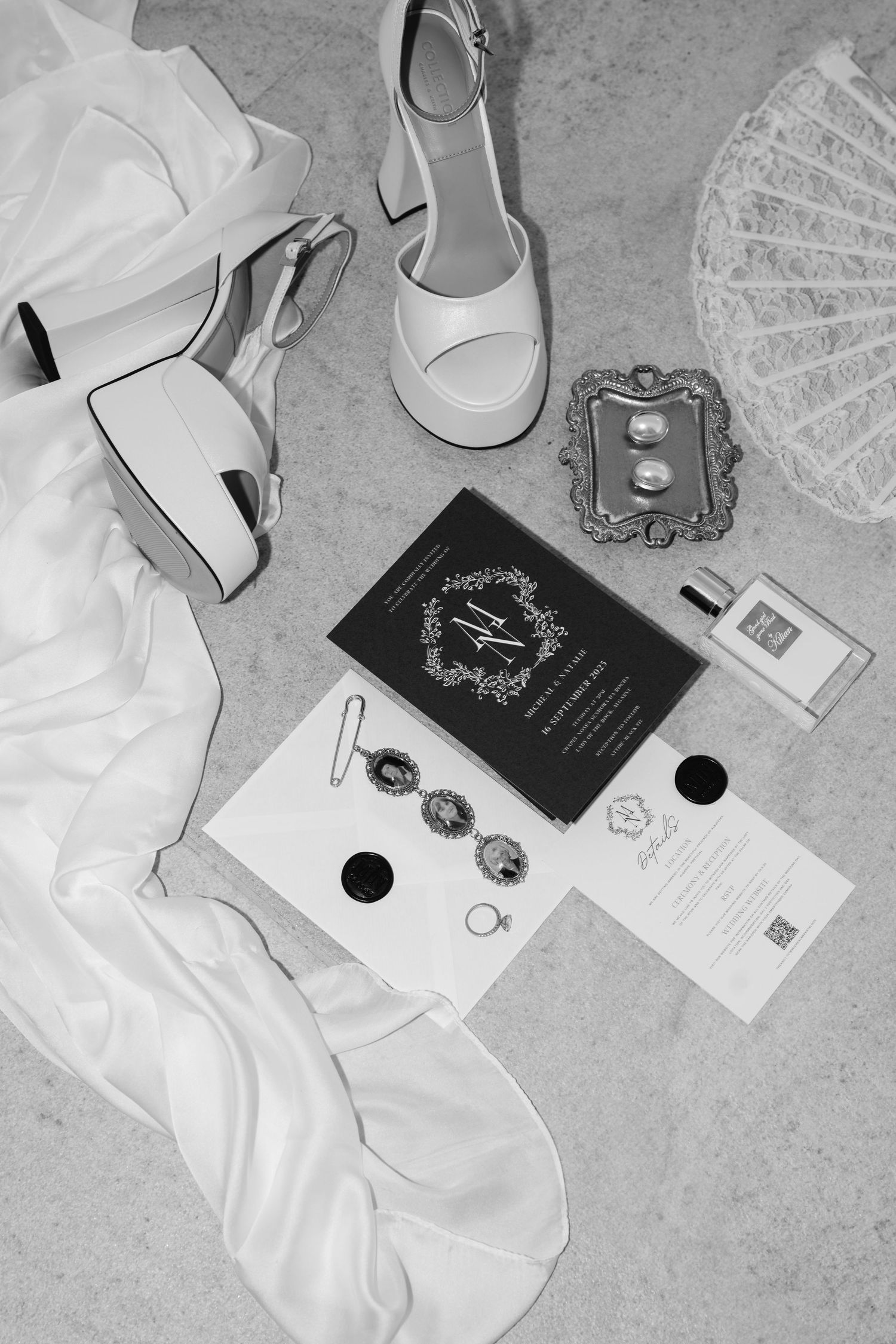Wedding details including white dress, invitations, and accessories in black and white.