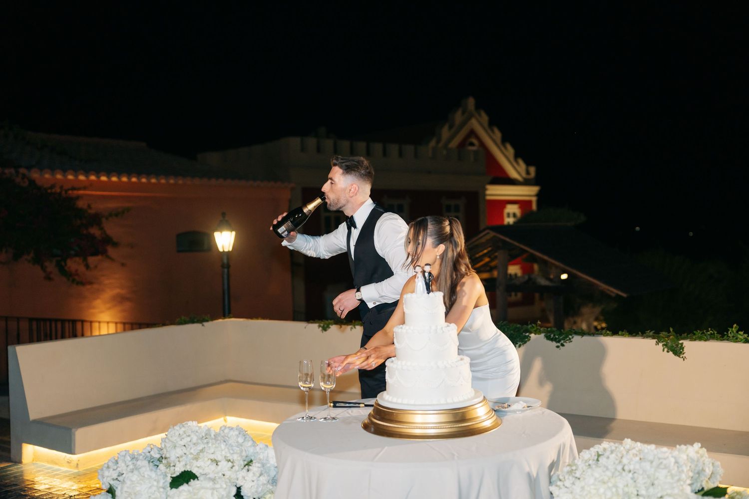 Wedding reception celebration with cake and champagne at an outdoor venue.