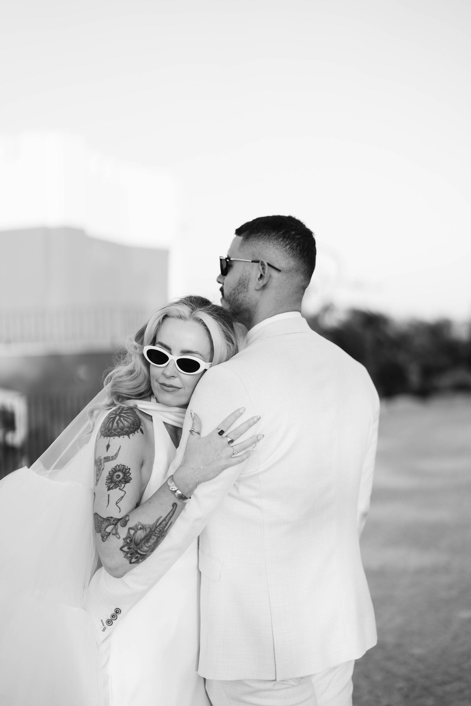 Black and white portrait with retro sunglasses and tattoo details.