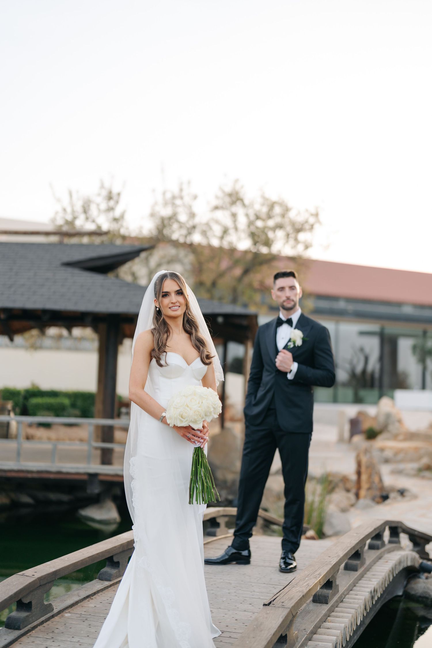 Wedding couple shares intimate moments on a rustic wooden walkway.