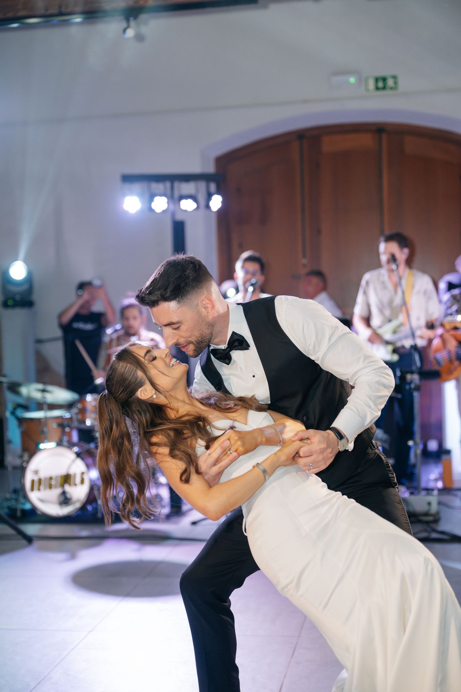 A dramatic dip during a wedding first dance with a live band performing in the background.