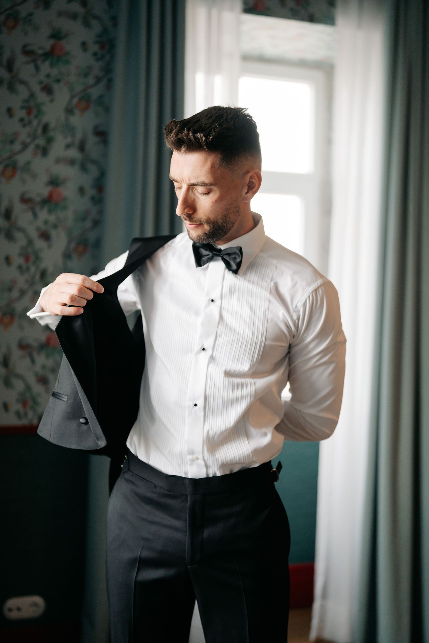 Person in formal white shirt and black vest prepares for special occasion.