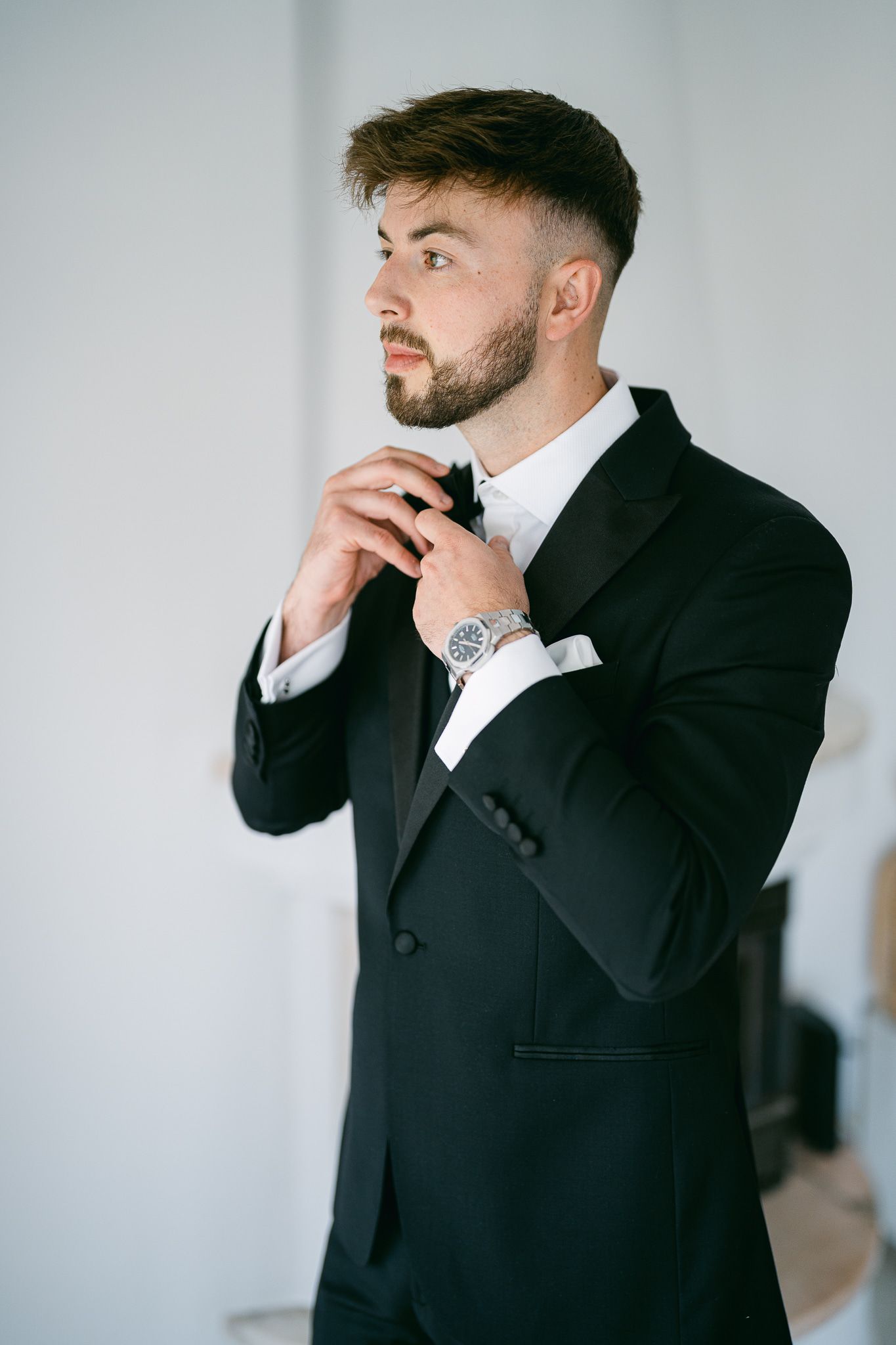 Side profile shots of a person in formal black suit adjusting their collar.