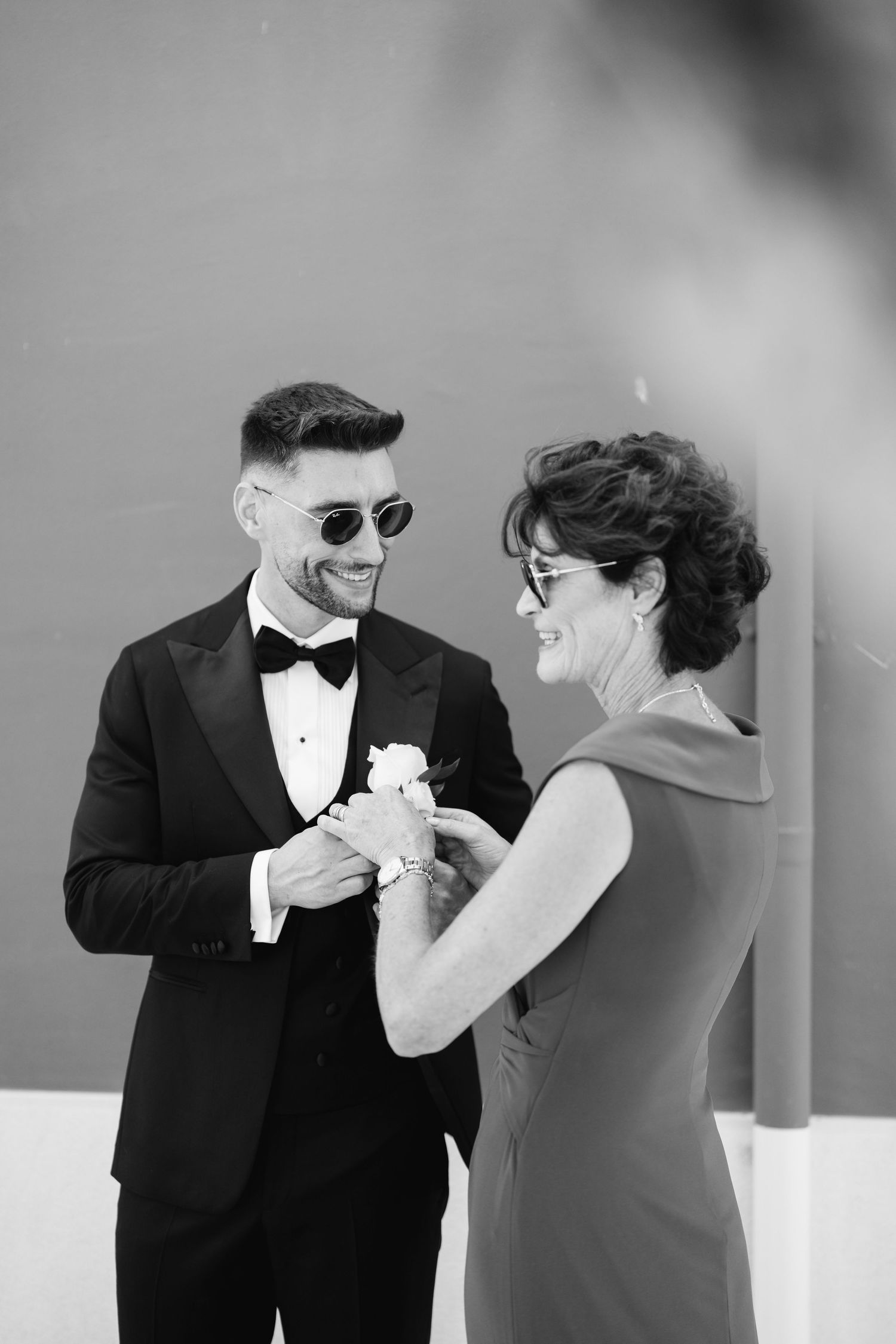 Candid black and white photo of two people laughing during a formal event.