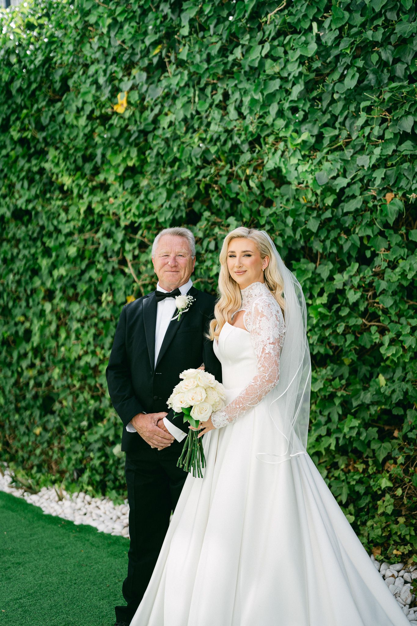 A touching wedding day reveal moment set against a wall of green ivy.