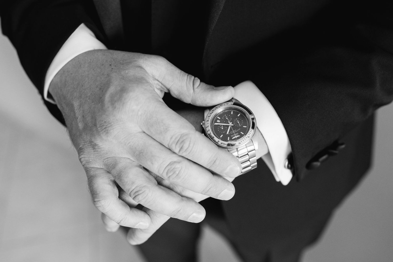 Close up of hands adjusting luxury watch on wrist.