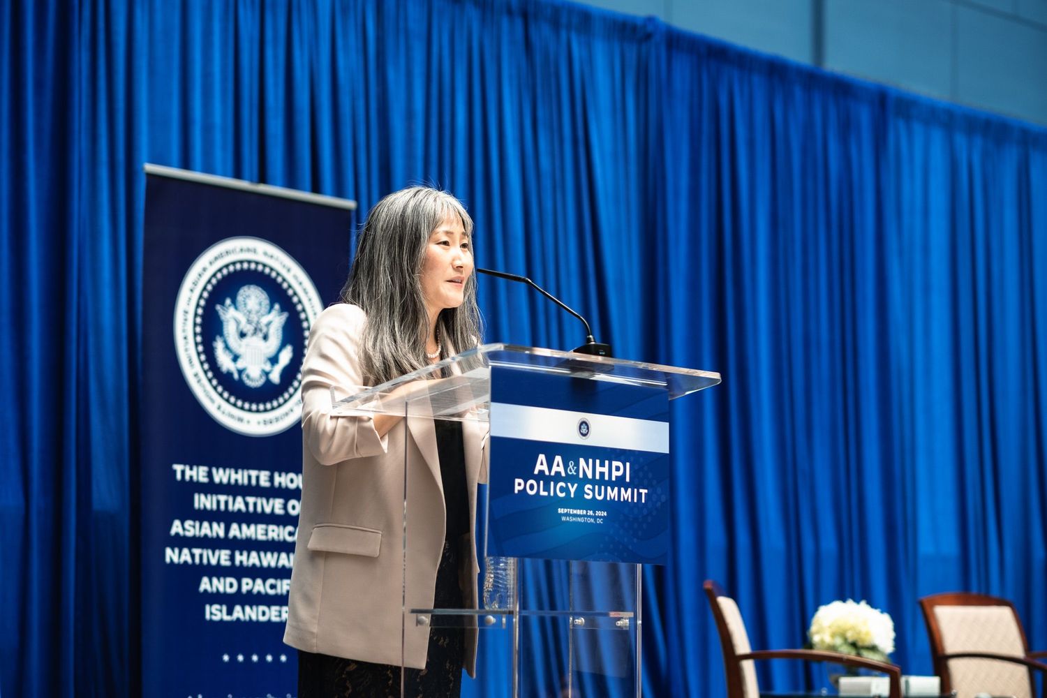 Woman speaking at podium during AA+NHPI Policy Summit at the White House Initiative on Asian Americans event.