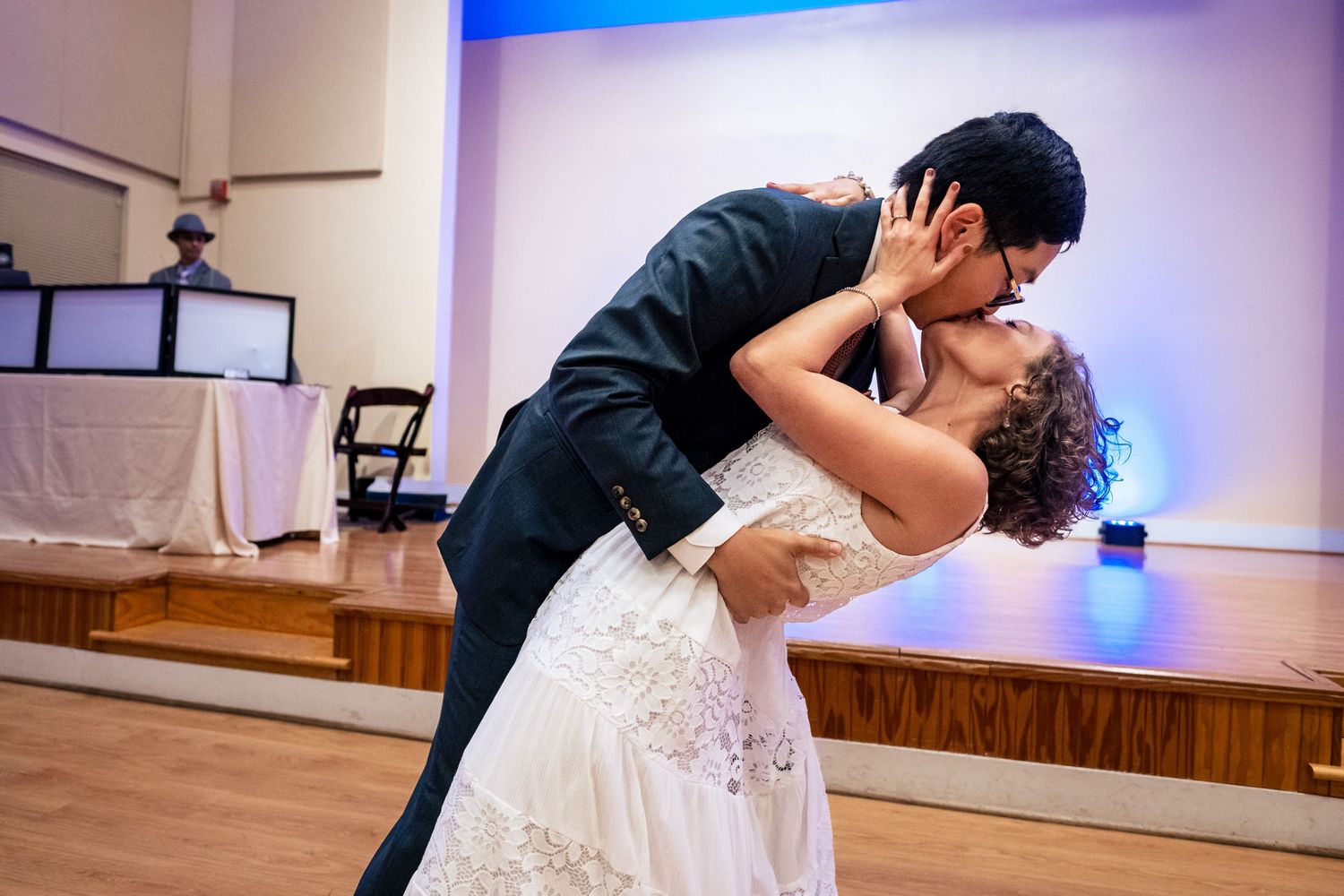 Bride and groom share a romantic dip kiss on the dance floor during their first wedding dance.