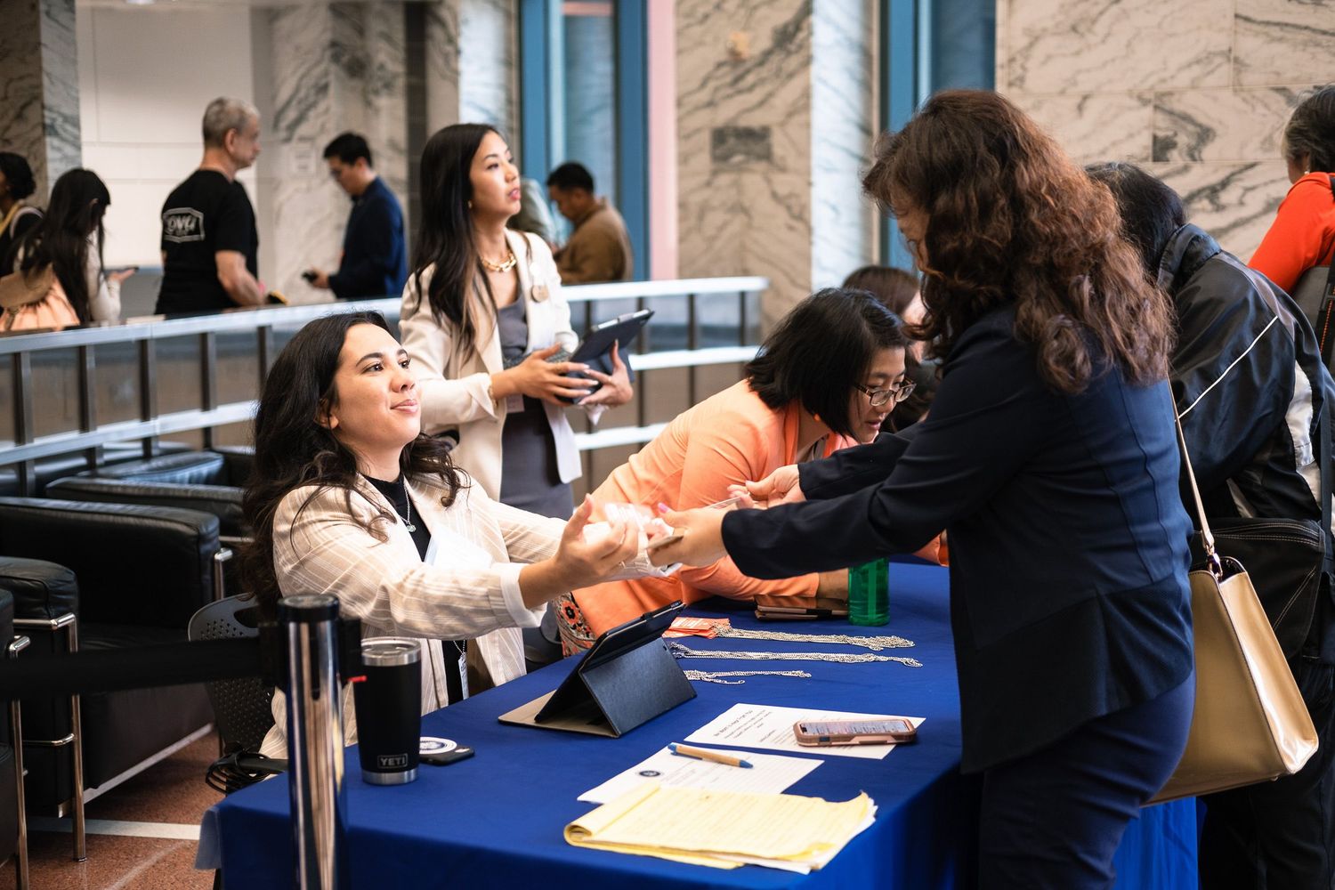 Attendees check in at a blue-draped registration table during a White House Initiative event for Asian Americans.