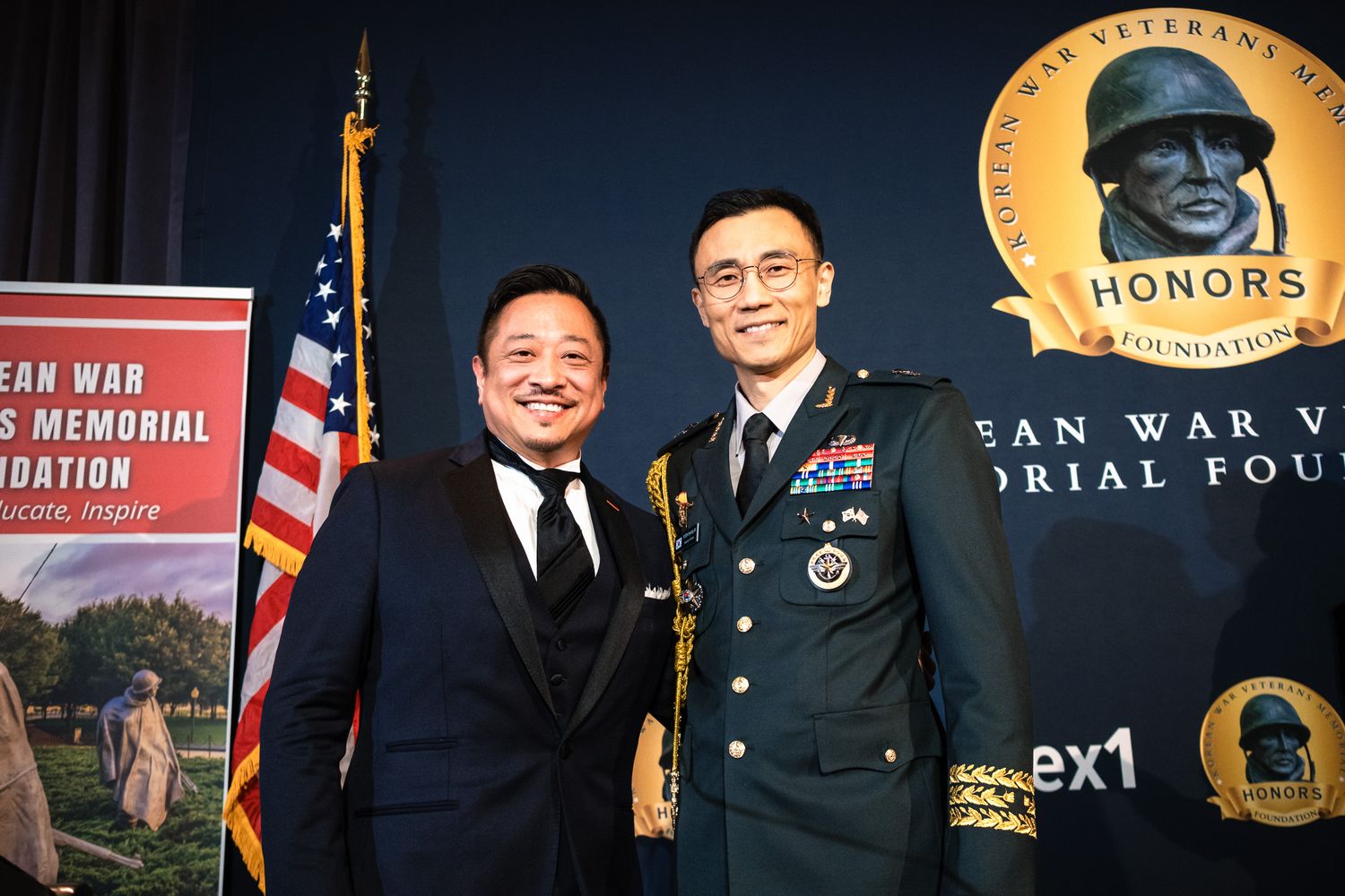 Two men pose at Korean War Veterans Memorial Foundation Honors event, one in military uniform.