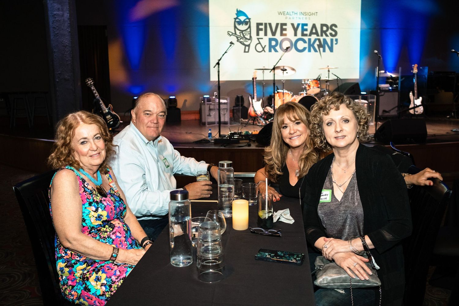 Four guests smile at a table at the Five Years & Rockin' anniversary gala event.