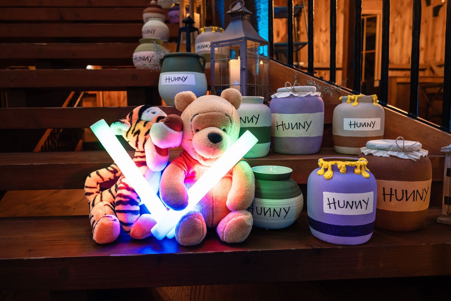 Winnie the Pooh stuffed animals and glowing LED light-up props displayed on wooden steps.