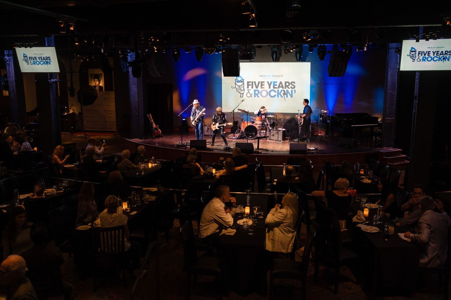 Live band performs on stage at Five Years Grookin anniversary event in a packed dimly lit music venue.