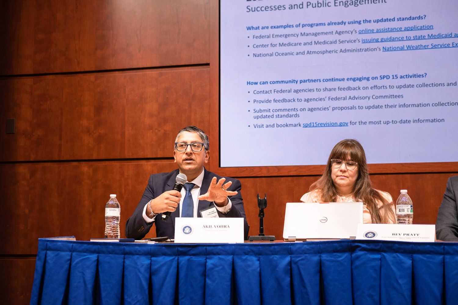 Panel discussion at a conference table with speakers presenting on SPD-13 successes and public engagement initiatives.