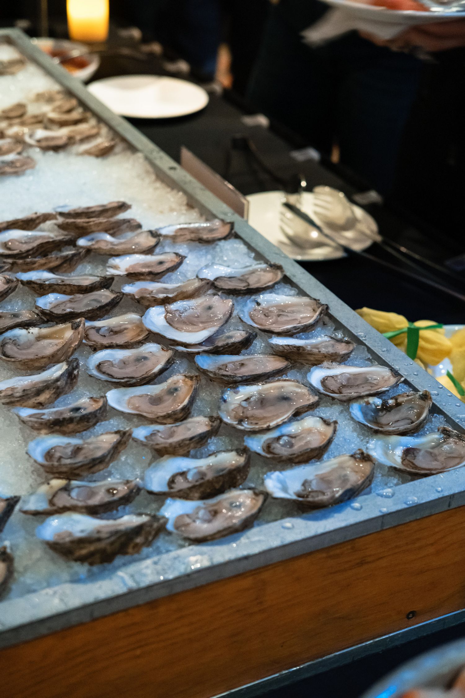 Fresh oysters on the half shell displayed on ice at a seafood buffet station during a catered event.