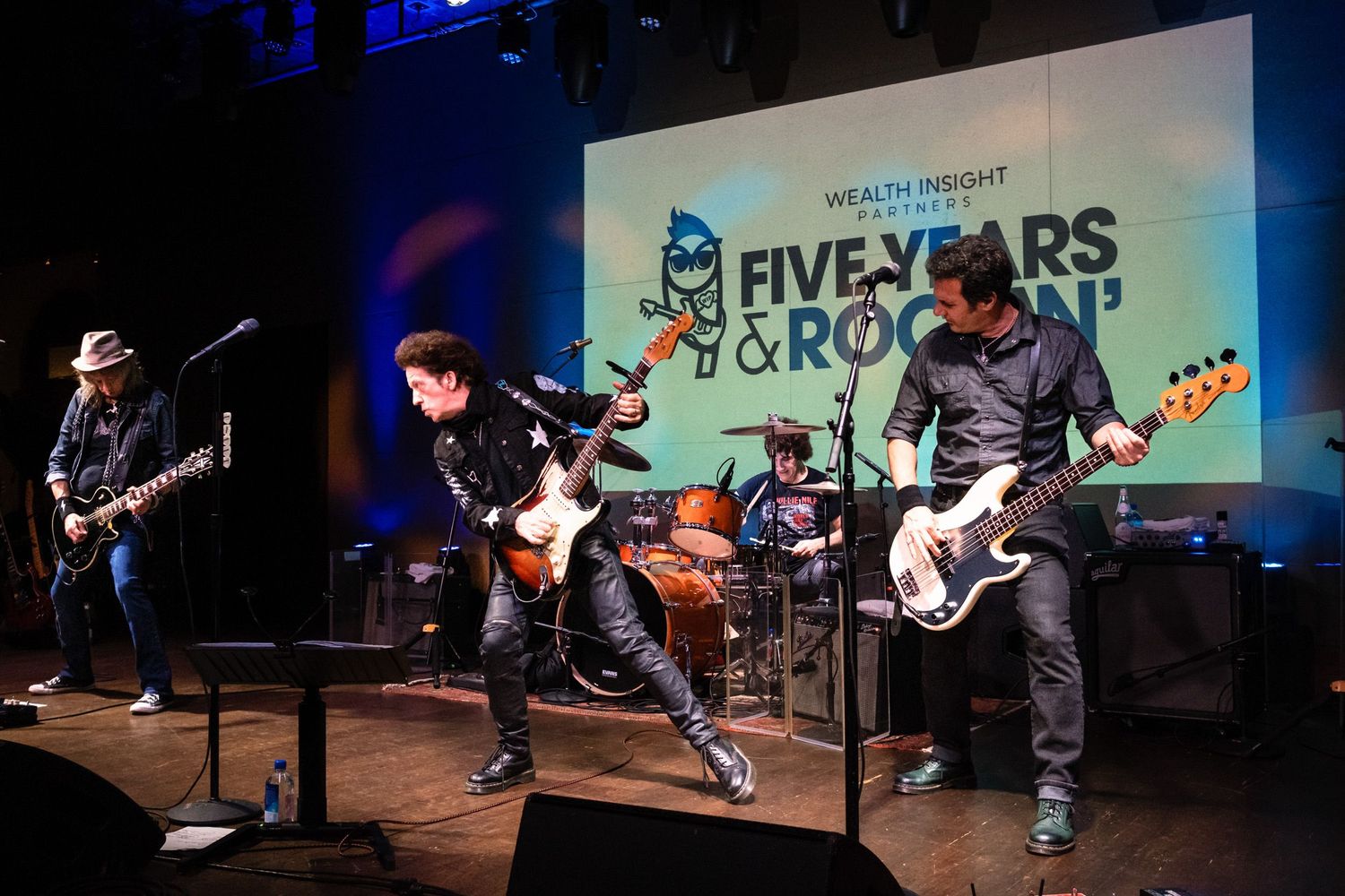 Live band performing on stage at Wealth Insight Five Years & Rockin anniversary event.
