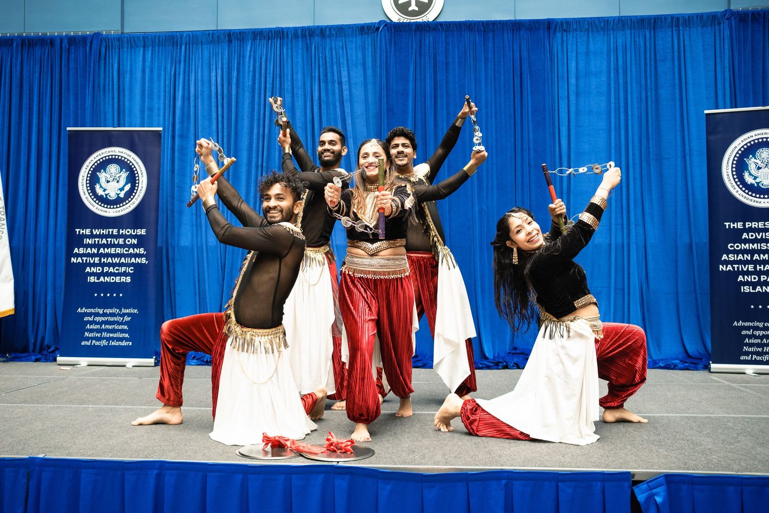 Colorful Bollywood dancers perform at White House AANHPI Heritage Month celebration on stage.