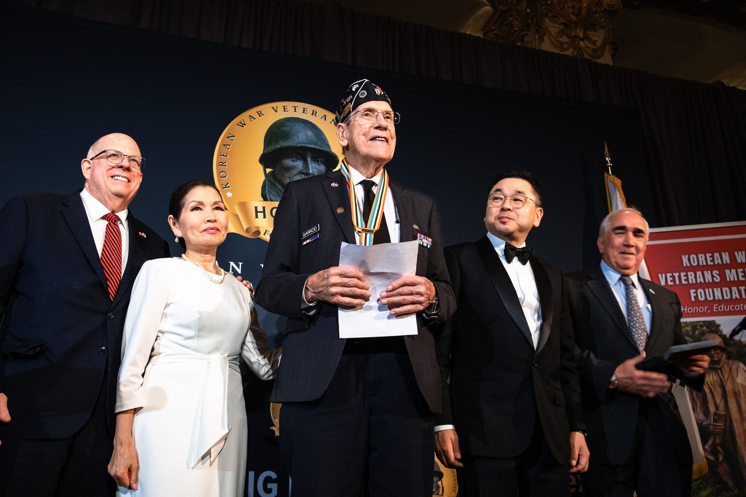Five honorees stand together on stage at Korean War Veterans Memorial Foundation Honors ceremony.