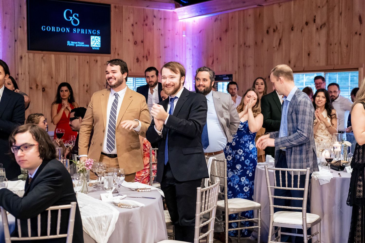 Wedding guests laugh and celebrate during reception speeches at Gordon Springs venue.