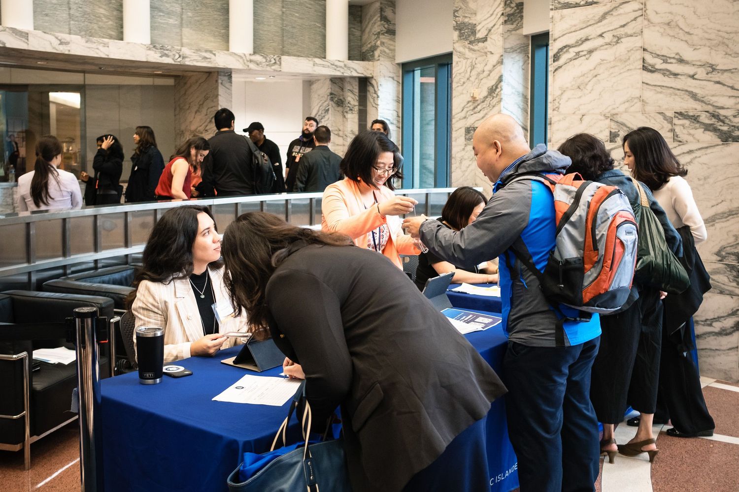 Diverse attendees register at a White House Initiative on Asian Americans and Pacific Islanders event table.