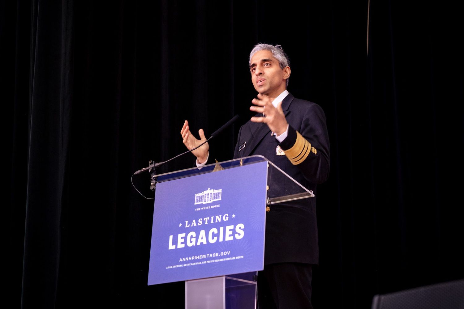 Official in military uniform speaks at Lasting Legacies podium during formal event.