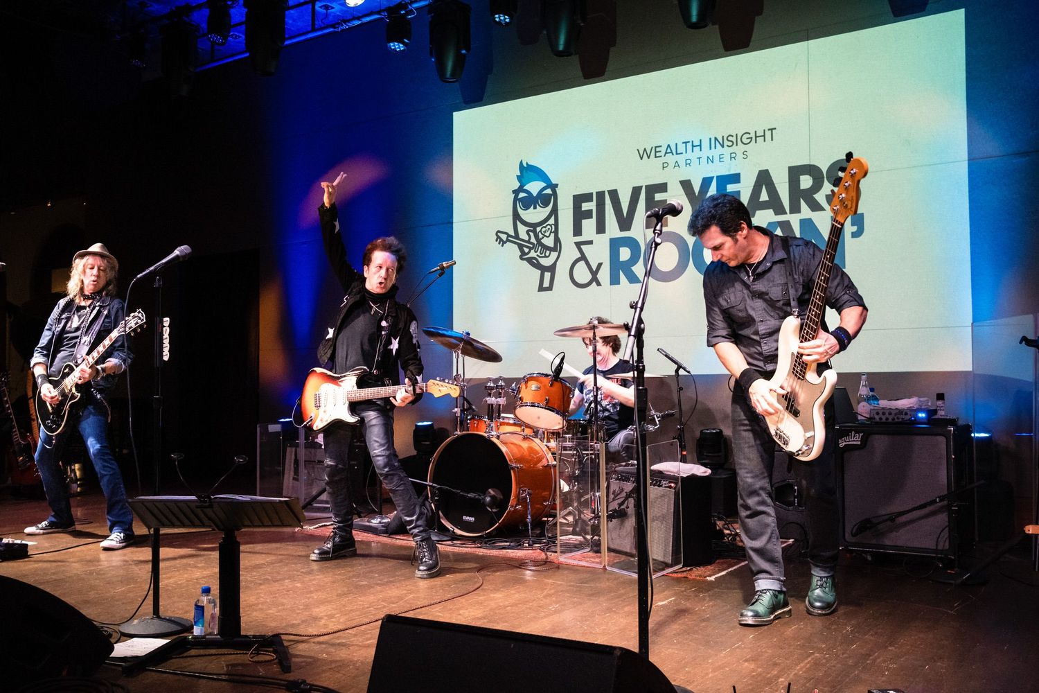 Electric guitar players performing on stage at Wealth Insight Five Years & Rockin celebration.