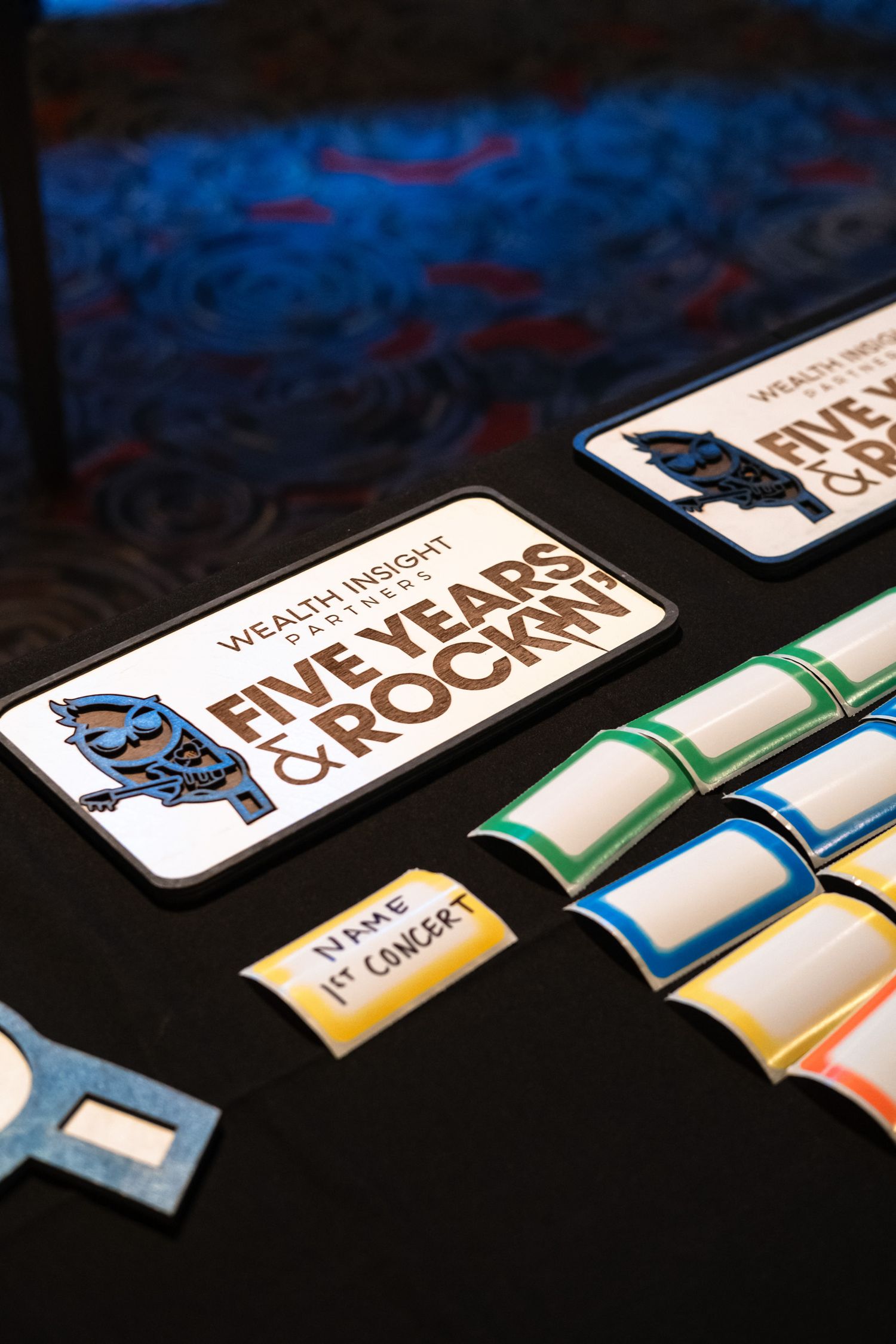 Wealth Insight Partners Five Years & Rockin anniversary event table display with colorful rolled certificates and signage.