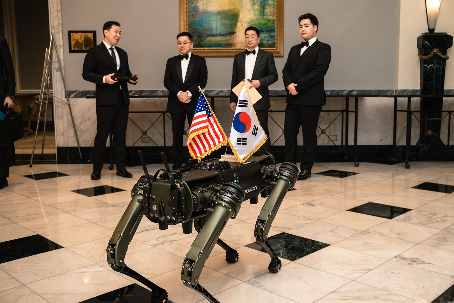 Boston Dynamics Spot robot dog at formal US-South Korea diplomatic event with four men in tuxedos.