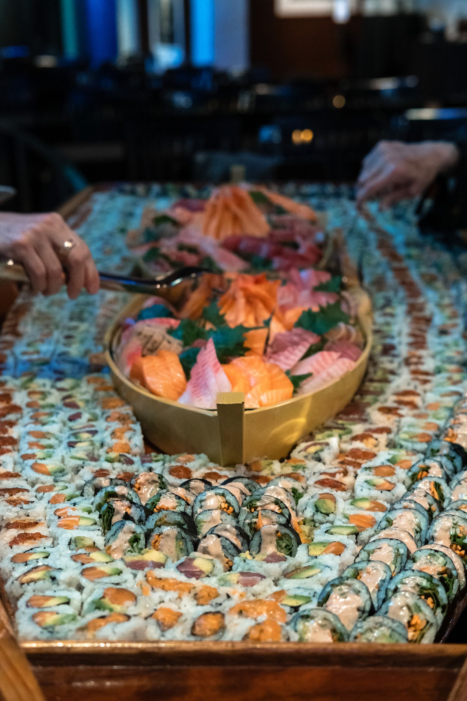 Elaborate sushi platter with rolls and sashimi displayed on a decorative table at a Japanese restaurant.