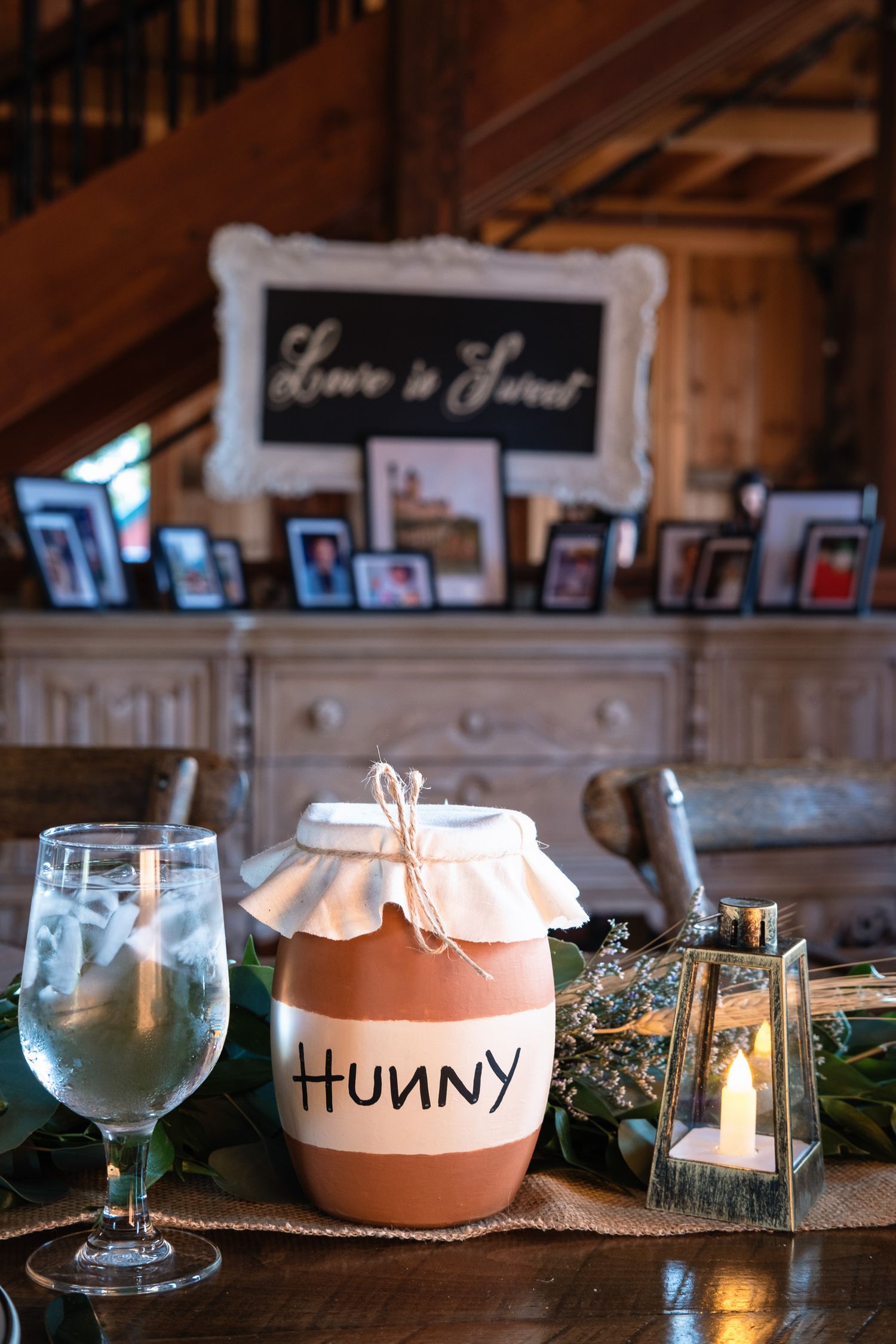 Winnie the Pooh themed Hunny pot centerpiece on wedding reception table with Love is Sweet sign.