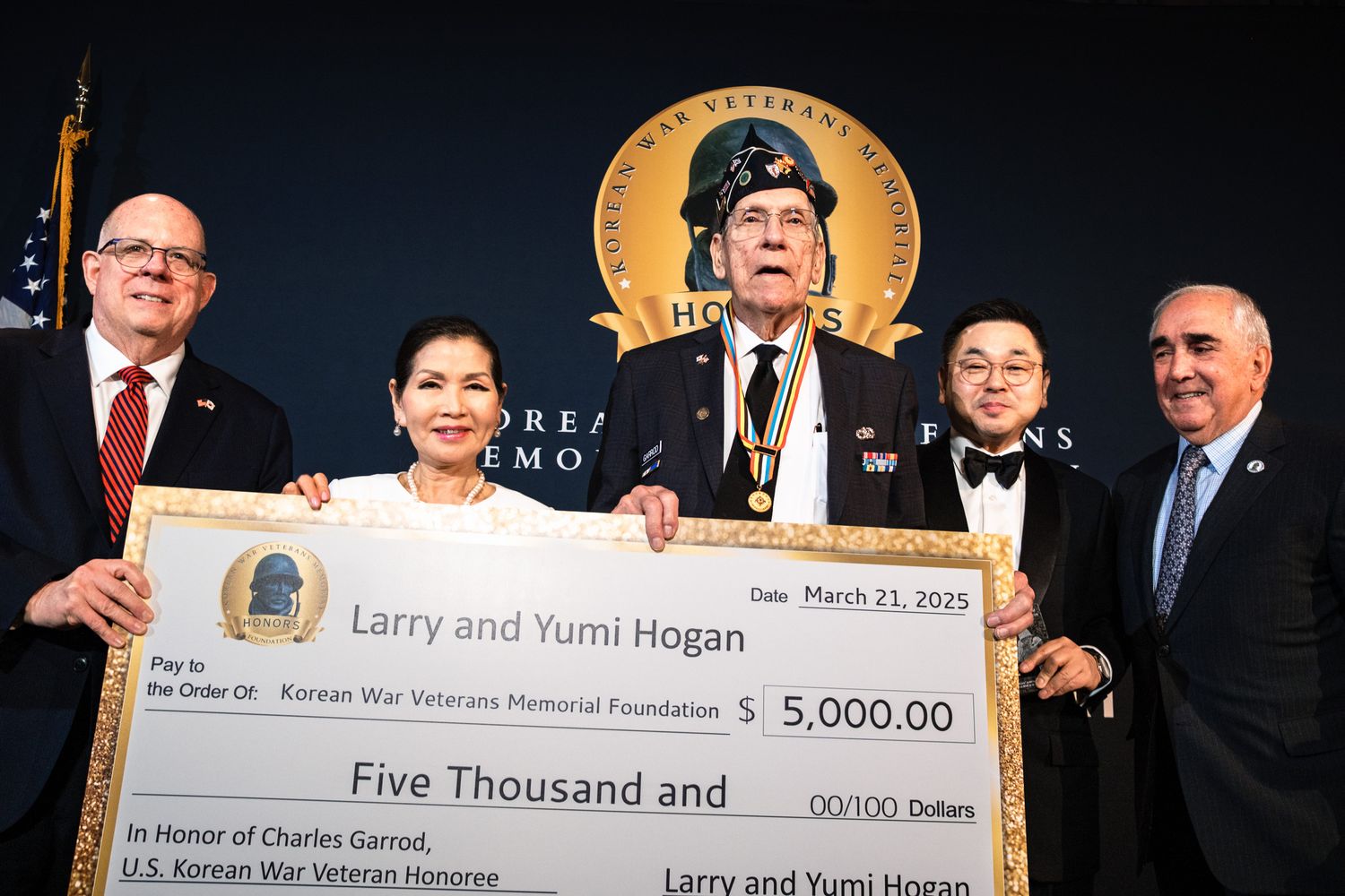 Larry and Yumi Hogan present $5,000 check at Korean War Veterans Memorial event.