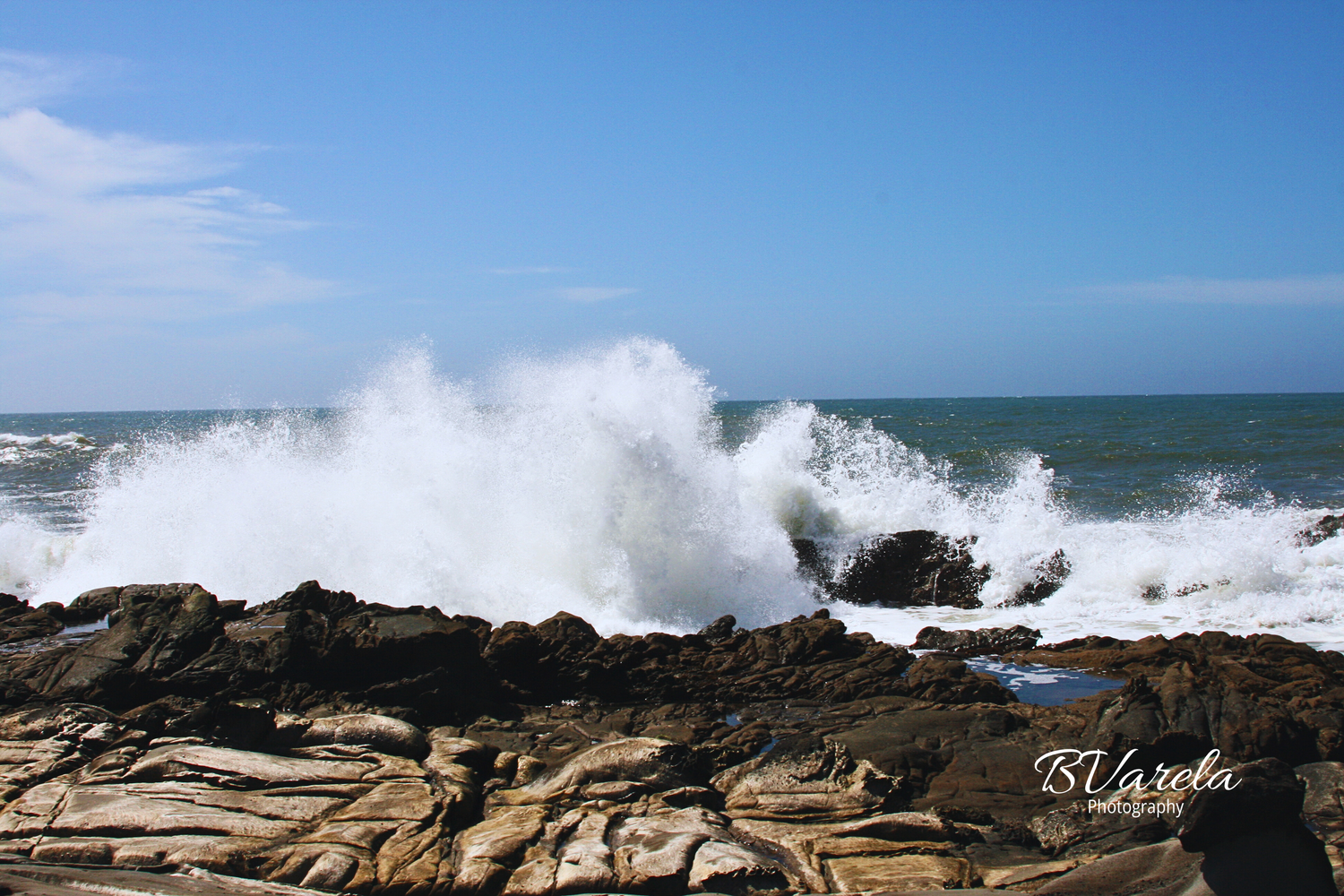 Powerful ocean waves crashing against rocky shoreline under blue sky. pescadero beach, photographer, half moon bay