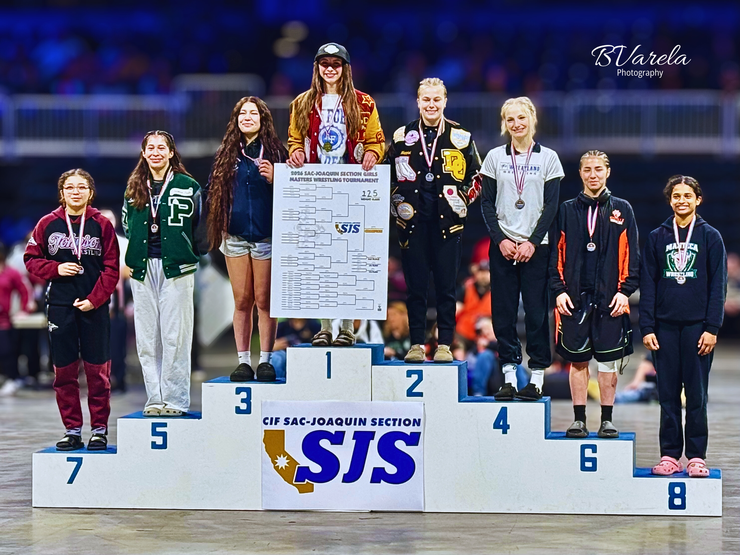 Athletes stand on podium at CIF San Joaquin Section wrestling championship awards ceremony. sports photography